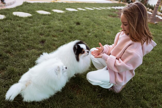 ハイビューを再生する女の子とかわいい白い子犬