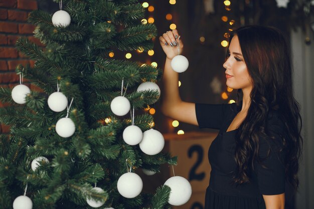 A girl decorates a Christmas tree