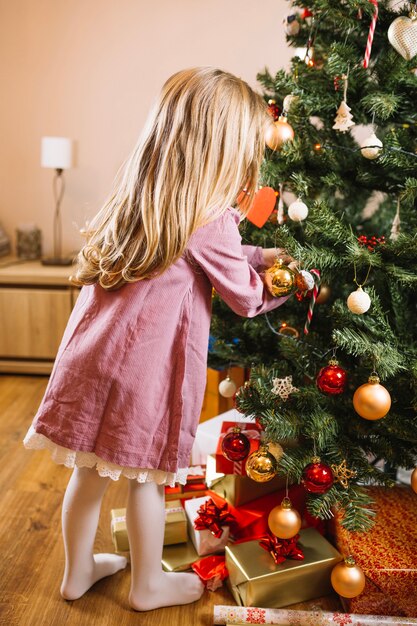 大きなクリスマスツリーを飾る少女