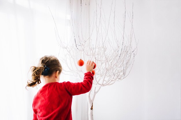 Ragazza che decora l'albero di Natale