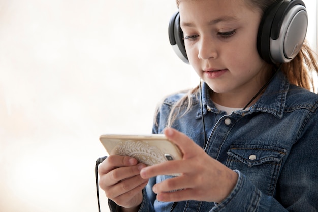 Ragazza in camicia di jeans tramite smartphone