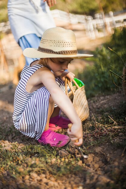 Girl digging the soil with trowel