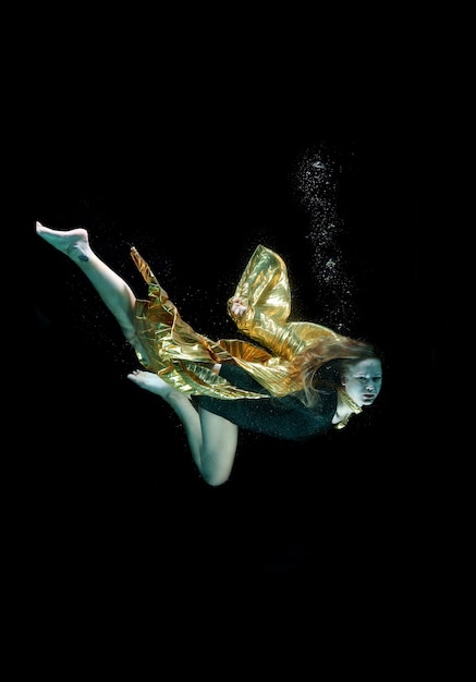 Girl diving with a golden cape