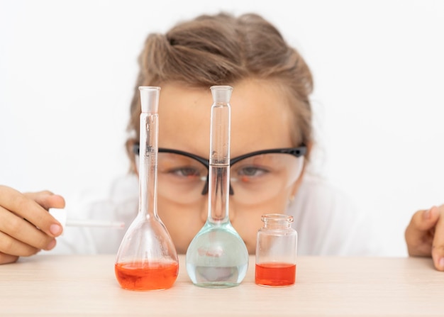 Free photo girl doing chemistry experiments with test tubes