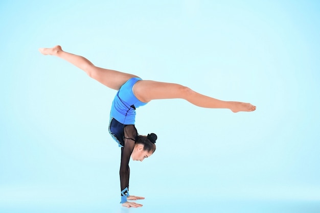 Free photo girl doing gymnastics dance on blue