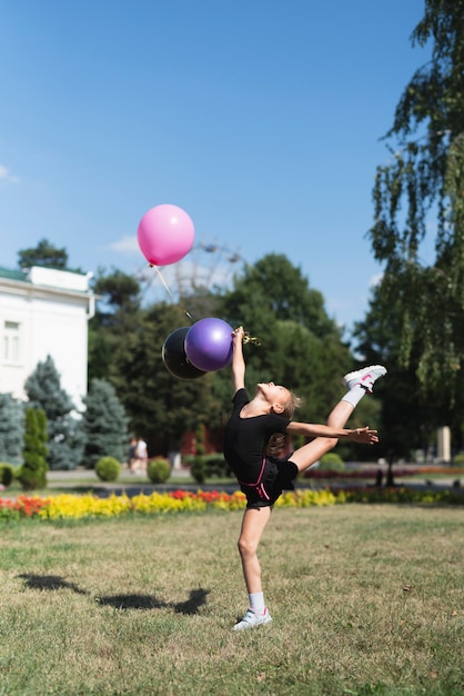 Бесплатное фото Девушка делает гимнастику с воздушными шарами