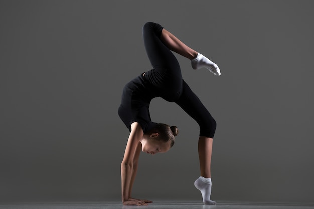 Girl doing handstand with a leg on the floor