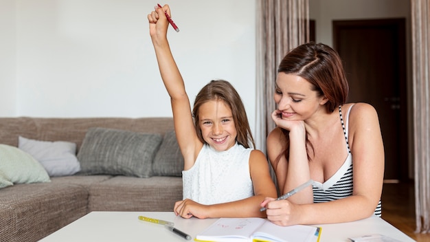 Girl doing her homework together with mom