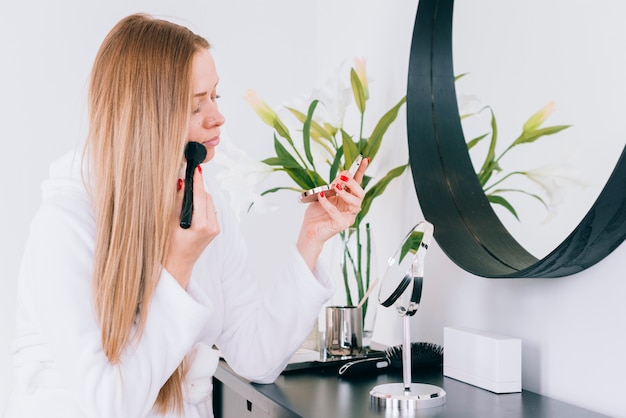 Free photo girl doing her make up at the bathroom