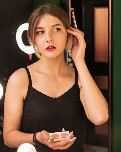 Girl doing her make up in a green room