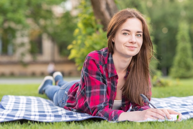 Free photo girl doing homework on picnic cloth