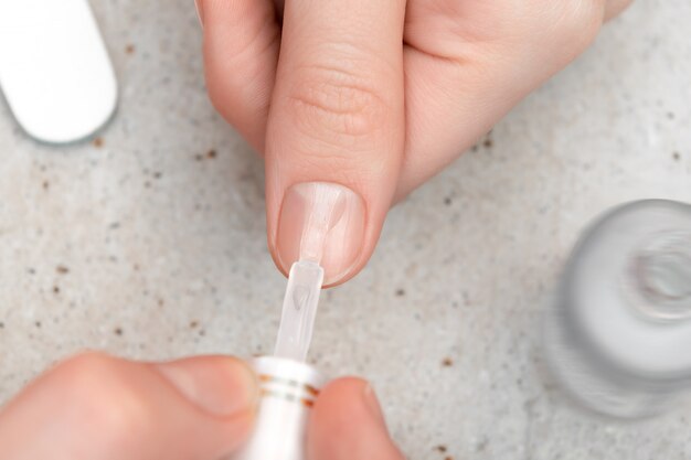 Girl doing manicure by herself, close up.