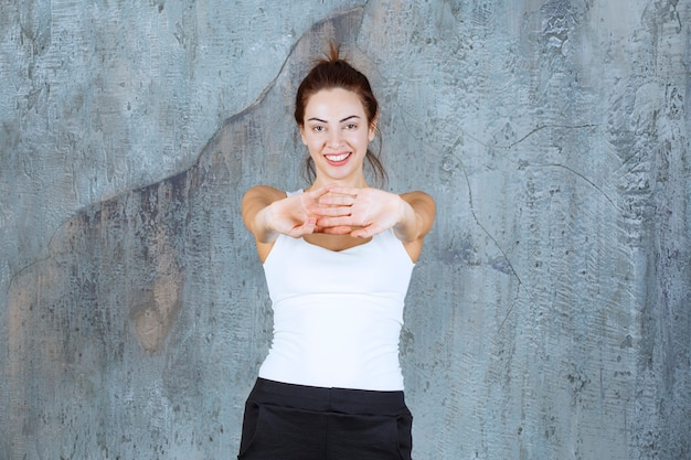 Foto gratuita ragazza che fa allenamento dei muscoli shouder e del braccio.