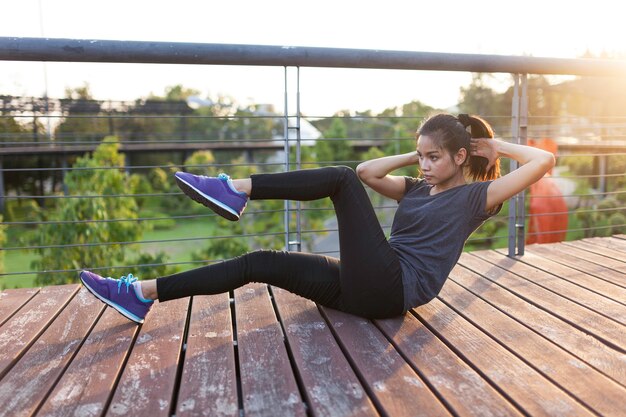 Girl doing sit-ups outdoors