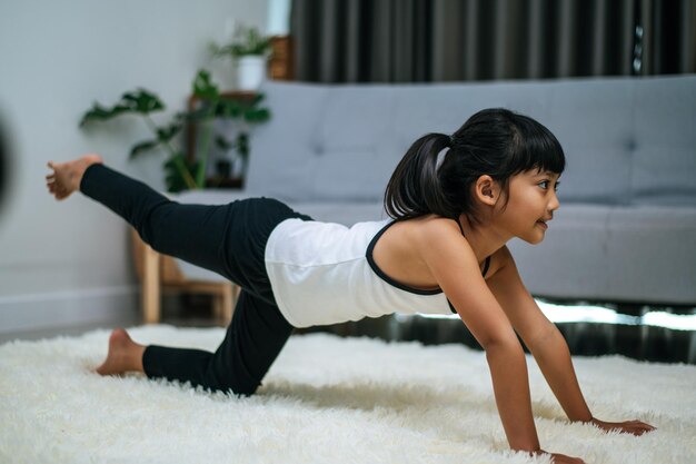 Girl doing yoga in room on white carpet. Selective focus.