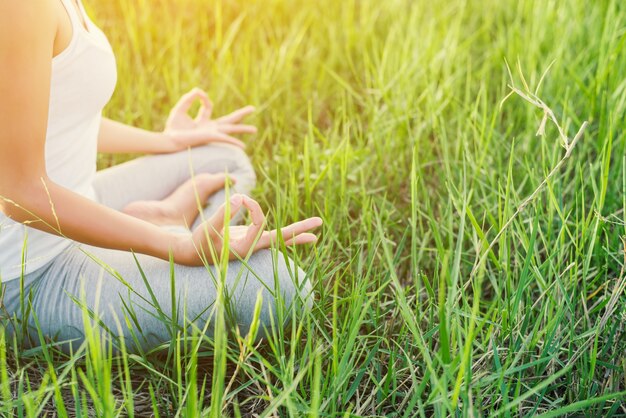 Girl doing yoga sitting in the field