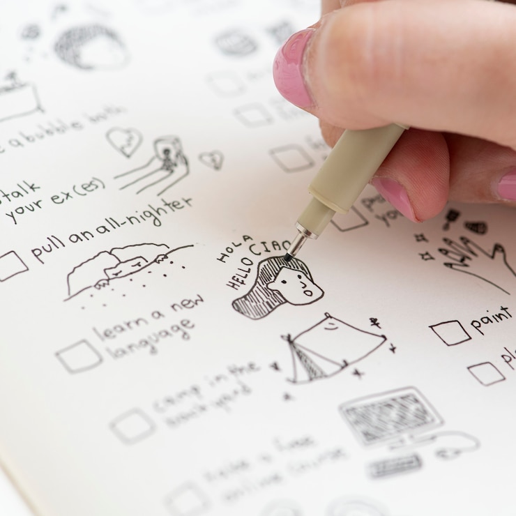 Free Photo girl doodling and making a checklist in a notebook