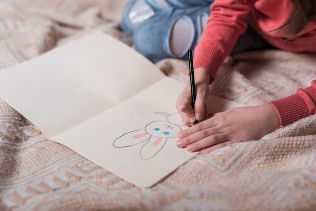 Girl drawing bunny on paper