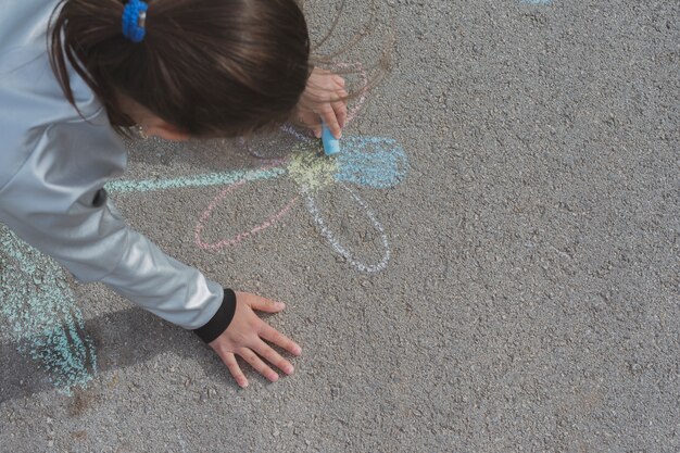 チョークで道路上を描く少女