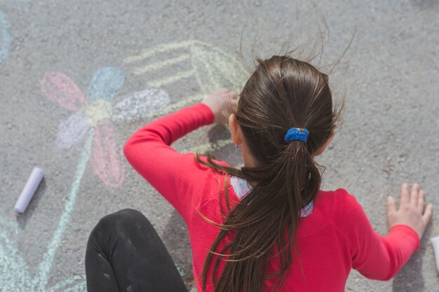Girl drawing with chalk on road
