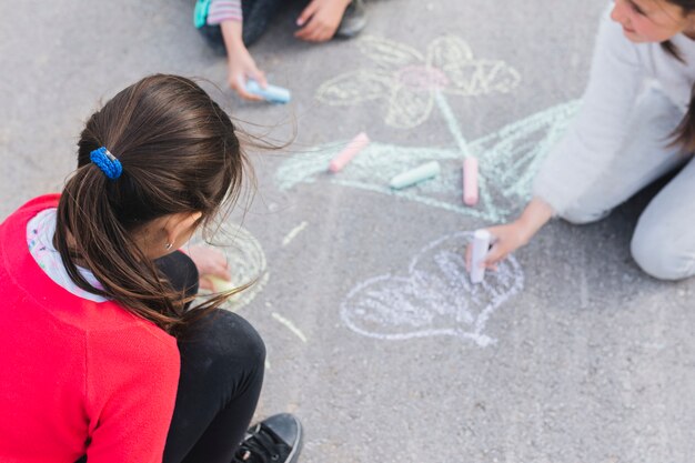 Girl drawing with chalk on road