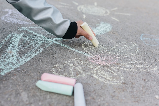 チョークで道路上を描く少女