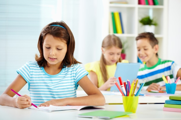 Free photo girl drawing with a pink pencil