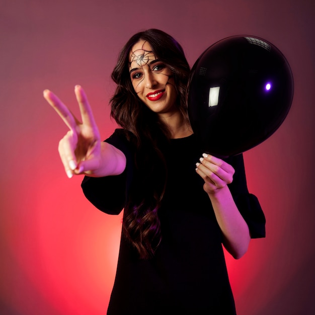 Girl dressed as witch making peace gesture