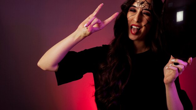 Girl dressed as witch making rock gesture