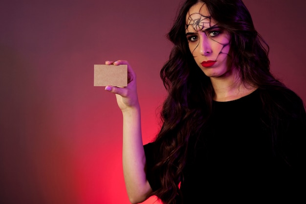 Girl dressed as witch showing business card