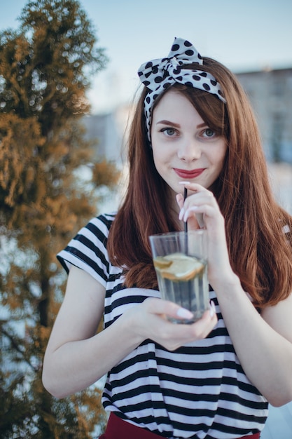 Girl drinking from a glass with a straw