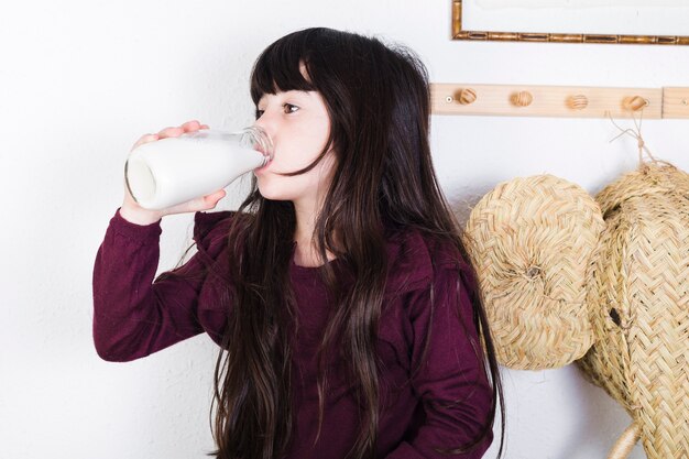 Девушка пьёт молоко из бутылки