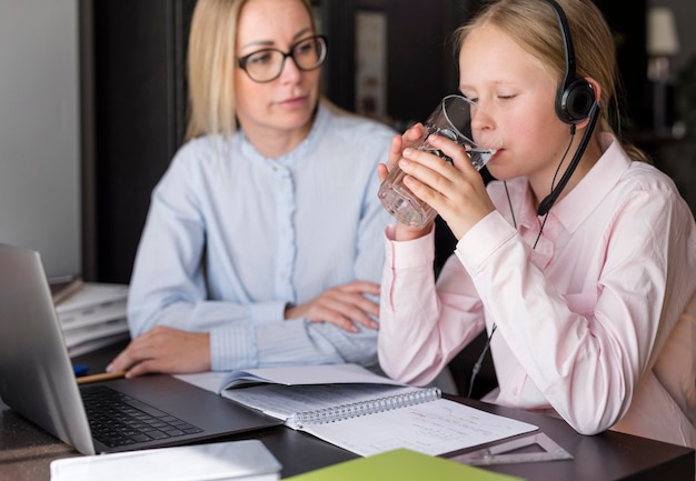 Girl drinking water next to teacher