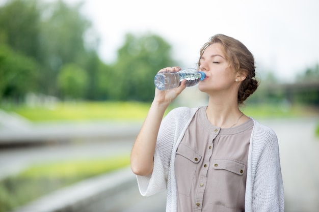 Girl drinking water with blurred background