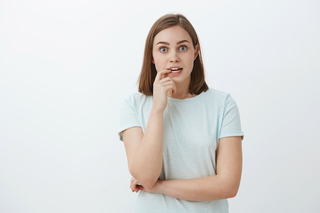 Girl eager to know end of story dying from excitement and interest. Portrait of curious enthusiastic and thrilled good-looking woman tv series fan biting fingernail and staring focused