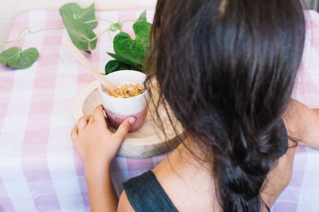 カップから穀物を食べる少女