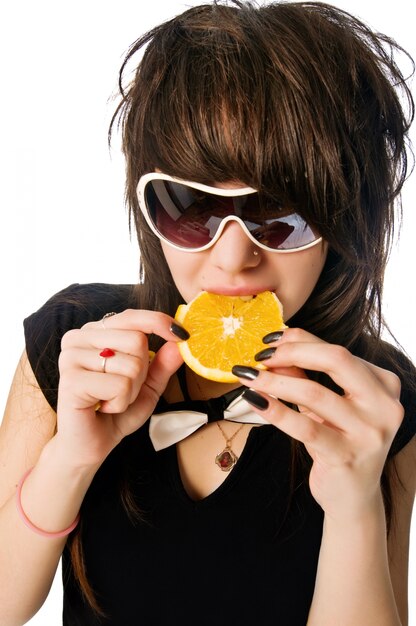 Девушка ест оранжевый