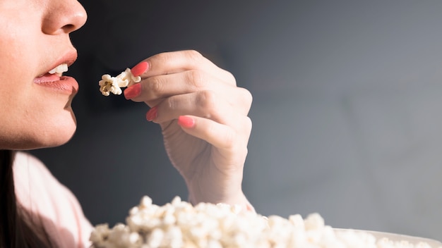 Free photo girl eating popcorn in cinema