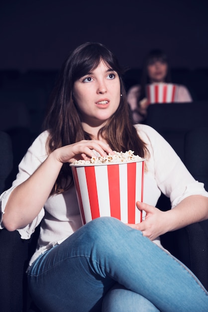 Ragazza che mangia popcorn nel cinema