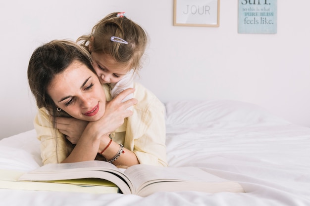 Girl embracing reading mother