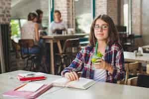 Foto gratuita ragazza che beve mentre studia