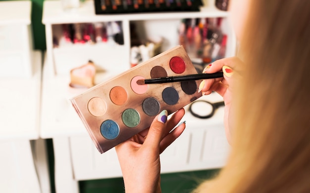 Girl filling brush with make up