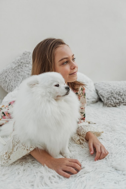 Girl and fluffy dog looking away