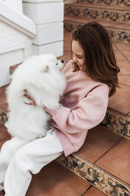 Girl and fluffy dog on the stairs side view