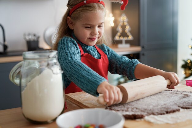 Girl focus on rolling gingerbread dough