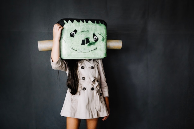 Girl in Frankenstein mask scratching her head