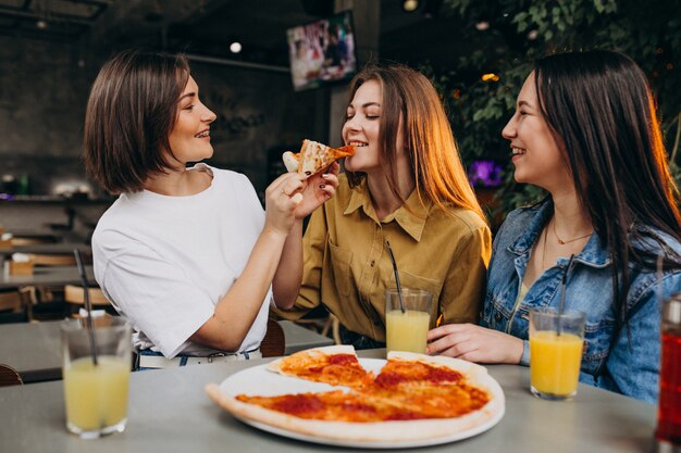 Girl friends having pizza at a bar at a lunch time