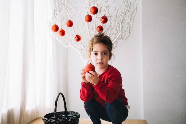 Free photo girl in front of tree with christmas balls