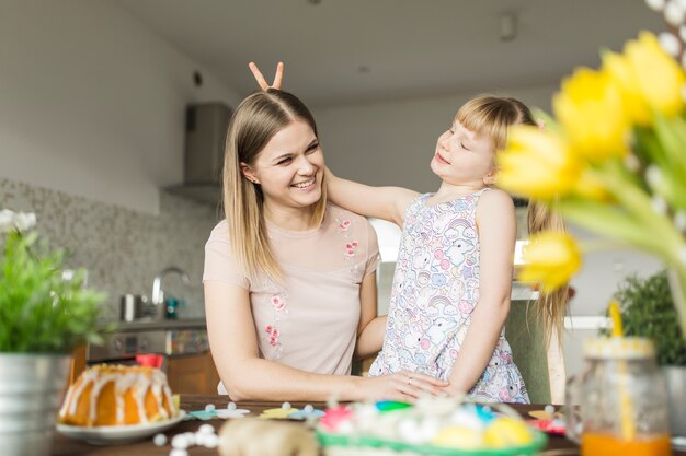 Girl gesturing horns to mother