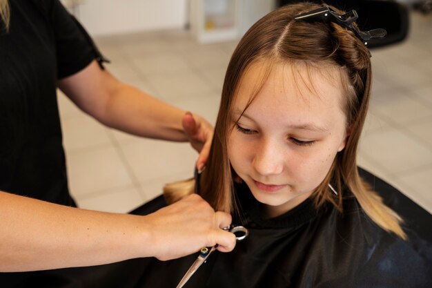 Girl getting haircut at salon high angle